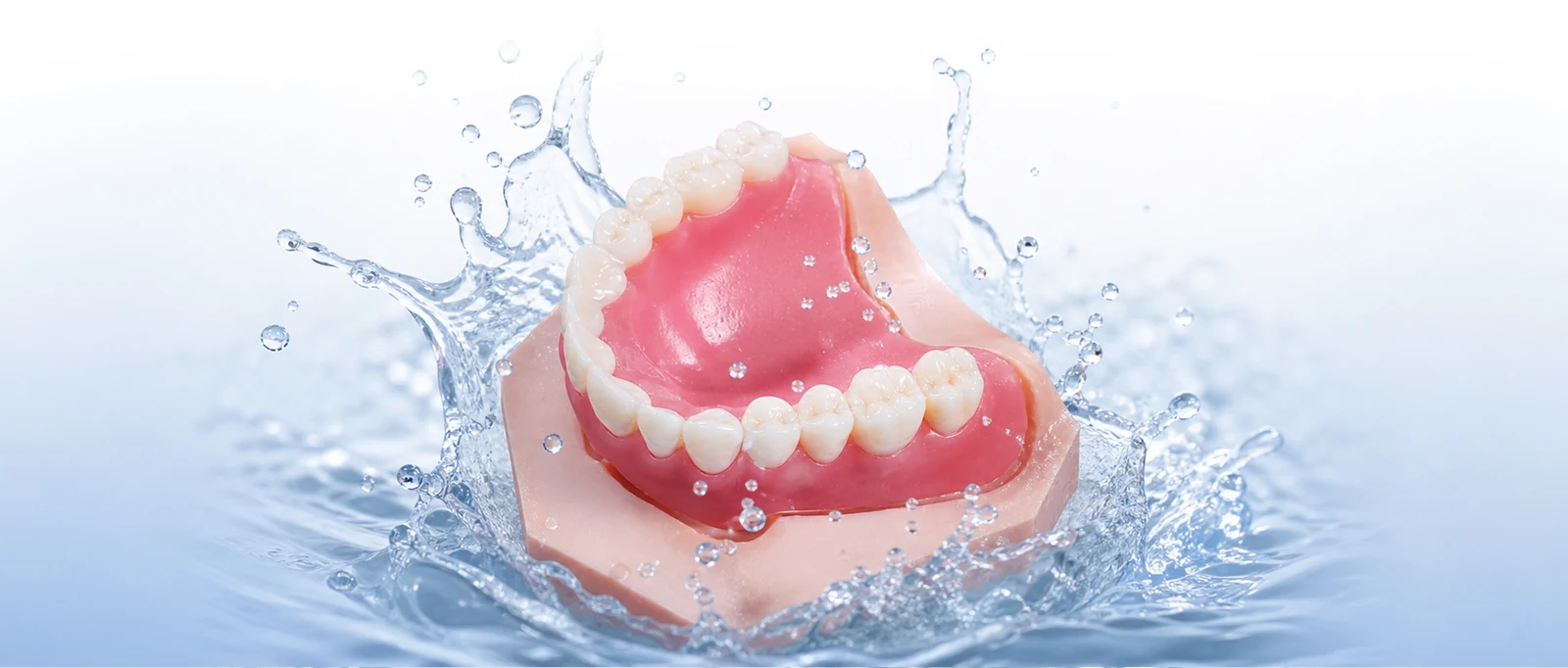 Denture model with a water splash illustrating ultrasonic cleaning